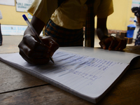 A High school student record her temperature check in a school register at the entrance of Girls Junior Grammar School, S.W, Ikoyi, Lagos on...