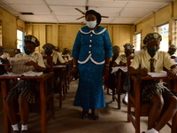 A teacher gives a lesson to students at Girls Junior Grammar School, S.W, Ikoyi, Lagos on August 3, 2020 on the first day after resumption o...