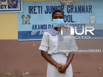 A High school student with a face mask pose for a photo at the entrance of Ireti Junior Grammar Schol, Ikoyi, Lagos on August 3, 2020 on the...