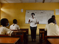 A teacher with a face mask gives a lesson to students at Ireti Junior Grammar Schol, Ikoyi, Lagos on August 3, 2020 on the first day after r...