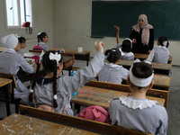 A teacher interacts with students in a classroom at a United Nations-run school as a new school year begins as Palestinians ease the coronav...
