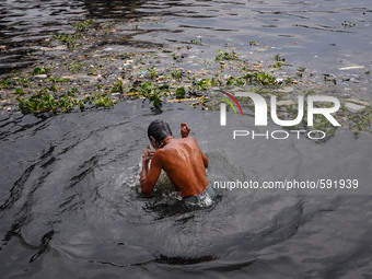 May 17, 2015 - Dhaka, Bangladesh - A man is taking shower in heavily polluted water of the Burigonga river. (