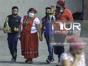 A family enters the temple of San Simón in San Andrés Itzapa, 50 kilometers west of the capital city of Guatemala, on August 14, 2020. Thous...