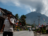 A boy walks with a mask when the Sinabung volcano activity releases volcanic ash at Payung village, on August 17, 2020 in Karo Regency, Nort...