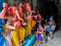 An artisan giving final touches to an idol of Ganesha.Ganesh chaturthi or Ganesh puja is the Hindu festival of celebrating the arrival of Lo...