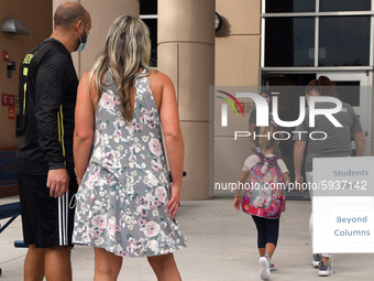 Parents watch as their child is escorted into the school building on the first day of in-person classes in Orange County at Baldwin Park Ele...