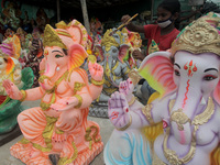 Elephant headed Indian Lord Ganesh idols are seen at the market as it made by the nomadic family peoples as they waits devotees to sale thei...
