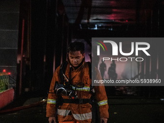 Firefighter still working hard on putting down fire at Prosecution Building office in Jakarta, Indonesia, on August 23, 2029. Many document...