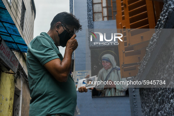A man offers prayer holding a picture of Saint Teresa from outside the tomb in front of Missionaries of Charity in Kolkata.A lady offer her...