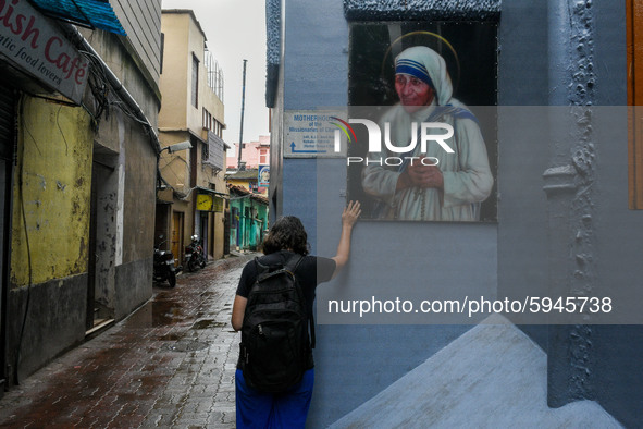 A lady pray in front of a picture of Saint Teresa , outside Missionaries of Charity in Kolkata.A lady offer her prayers from outside to the...