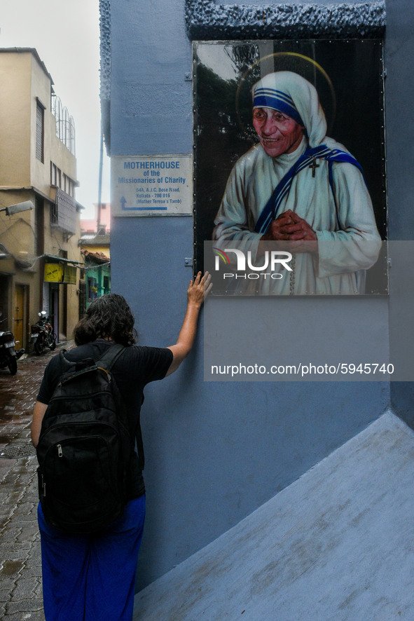 A lady pray in front of a picture of Saint Teresa , outside Missionaries of Charity in Kolkata.A lady offer her prayers from outside to the...