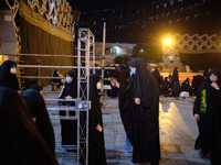 An Iranian volunteer takes the temperature of a Shi’ite mourner while attending a Moharram religious ceremony in the Imam Hussein square in...