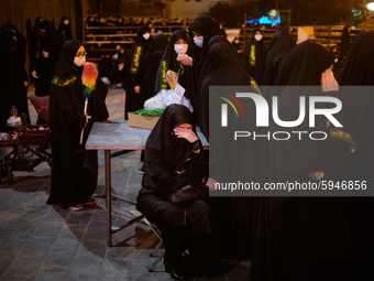 An Iranian veiled woman mourns while attending a Moharram religious ceremony in the Imam Hussein square in southern Tehran on August 25, 202...
