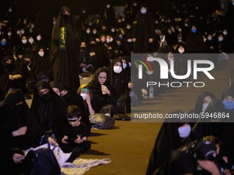 Iranian veiled women wearing protective face masks attend a Moharram religious ceremony in the Imam Hussein square in southern Tehran on Aug...