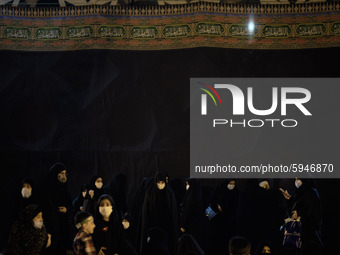 Iranian veiled women wearing protective face masks attend a Moharram religious ceremony in the Imam Hussein square in southern Tehran on Aug...