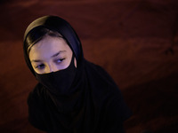 An Iranian young woman wearing a protective face mask attends a Moharram religious ceremony in the Imam Hussein square in southern Tehran on...