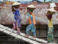 Day laborers unload sand from a cargo ship in Dhaka, Bangladesh on August 26, 2020. Dhaka is getting back to its normal life after months of...
