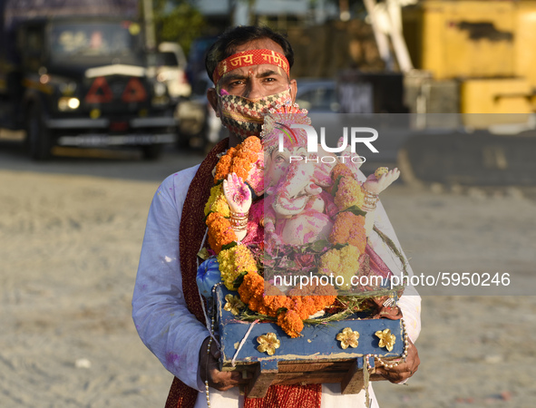 Devotee carry an idol of Lord Ganesha for immersion in the Brahmaputra River, during the Ganesh Chaturthi celebrations, in Guwahati, Assam,...