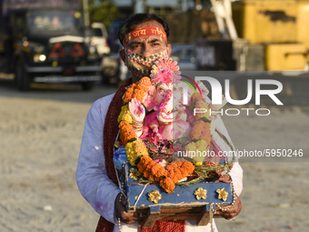 Devotee carry an idol of Lord Ganesha for immersion in the Brahmaputra River, during the Ganesh Chaturthi celebrations, in Guwahati, Assam,...