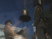 The reflection of Guards marking every of fallen heroes name with ringing the bell is seen near the monument during the commemorative ceremo...