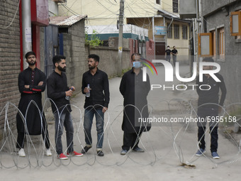 Kashmiri shite mourners stand behind the concertina wirew during restrictions on 10th of Muharram in Srinagar, Indian Administered Kashmir o...