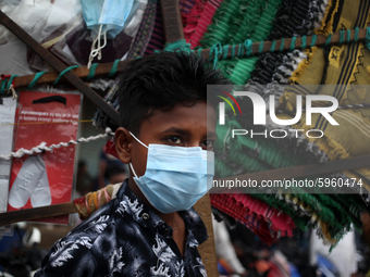 Ali Hossain (15) waits for customer besides a road in Dhaka , Bangladesh as he sells mask amid coronavirus pandemic on Motorcycle riders wai...