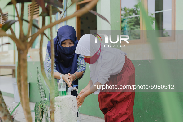 A teacher teach a student to wash her hands at Candirejo Elementary School, Semarang Regency, Central Java, Indonesia, on September 1, 2020....