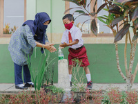 A teacher teach a student to wash his hands at Candirejo Elementary School, Semarang Regency, Central Java, Indonesia, on September 1, 2020....