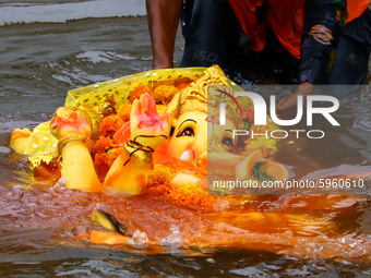 A Hindu Devotees immerse idols of the Hindu elephant god Ganesh, the deity of prosperity, in a pond during the Ganesh Chaturthi festival in...