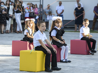 First graders sit on separate poufs for social distancing during a ceremony to mark the start of the new school year, amid the outbreak of t...