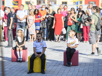 First graders sit on separate poufs for social distancing during a ceremony to mark the start of the new school year, amid the outbreak of t...