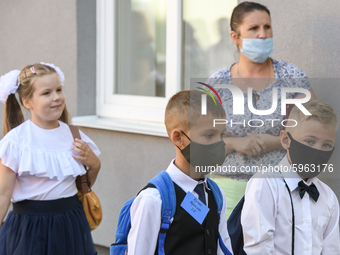 First graders wear protective face masks during a ceremony to mark the start of the new school year, amid the outbreak of the coronavirus di...