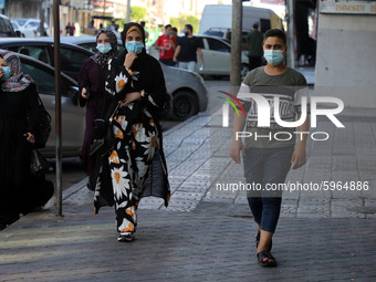 Palestinians wearing face masks walk on a street in Gaza City on September 2, 2020 during a lock down in the Palestinian enclave due to incr...