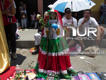 Devotees of Santa Muerte attend her altar in the Bravo de Tepito neighborhood with her image dressed in the colors of the Mexican flag becau...