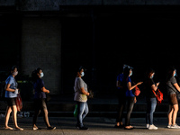 People wearing face masks queue at a bus stop in Manila, Philippines on September 2, 2020.(