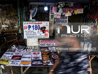 A man walks past a store selling COVID-19 themed shirts in Manila, Philippines on September 2, 2020.(
