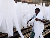 A worker dry fabric under the sun after dyeing them in a factory in Narayanganj, Bangladesh on September 03, 2020. (