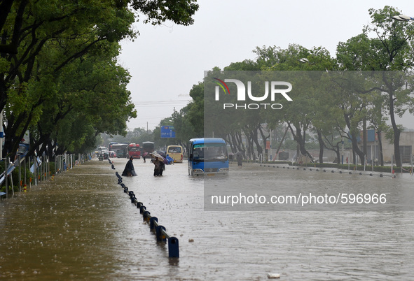 (150520) -- GUILIN, May 20, 2015 () -- People and vehicles are seen on a flooded street in Guilin, south China's Guangxi Zhuang Autonomous R...