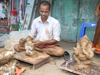 Tamil artisan creating small clay idols of Lord Ganesha (Lord Ganesh) at a workshop during the festival of Ganesh Chaturthi in Pondicherry (...