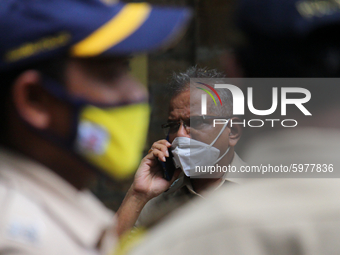 A police officer talks on a mobile phone outside the Narcotics Control Bureau (NCB) office during interrogation regarding the Sushant Singh...