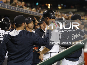 Detroit Tigers' Tyler Collins gets a dugout congratulation after scoring a run on a triple hit by Nick Castellanos in the eighth inning of a...