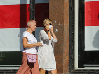Women walk past a store at a Khreshchatyk street with the window covered with Belarus national flag in Kyiv Ukraine, September 7, 2020.  (