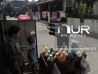 A seller herbal medicine wearing a face mask serves customers in Bogor, West Java, on September 8, 2020. During the pandemic, herbal drinks...