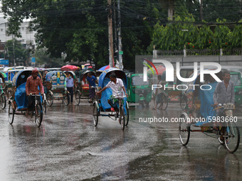 People ride on rickshaws during rainfall in Dhaka, Bangladesh on September 8, 2020.  (