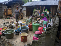 A mother is near her house which was damaged by floods in Oloboju Village, Sigi Regency, Central Sulawesi Province, Indonesia on September 9...