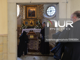 A nun and two monks seen praying next to Cardinal Marian Jaworski's coffin ahead of the funeral mass inside the Bernardine monastery in Kalw...
