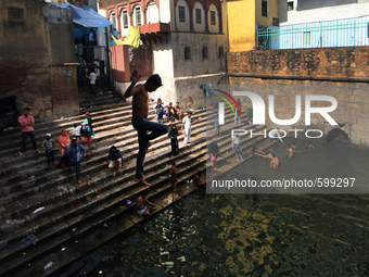 An Indian Child jumps into the water of a baoli at Nizamuddin Dargah in New Delhi on May 21 ,2015 .Temperature in the National Capital risin...