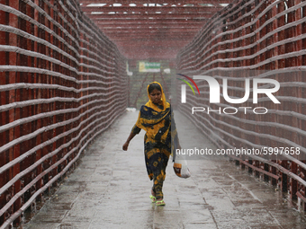 A woman walks on a foot over-bridge during the rainfall in Dhaka, Bangladesh on September 13, 2020. (