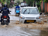 Commuters wade through a water logged street following heavy rains, in Guwahati, India on September 14, 2020. (