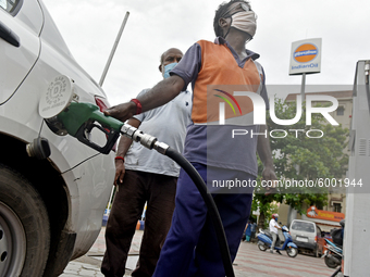 An Indian Oil worker puts the fuel pipe into a car for re-fuelling in Kolkata, India, 14 September, 2020. Indian Oil Corp will increase its...